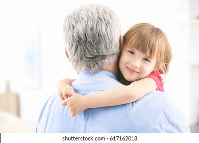 Girl Embracing Grand Father At Home