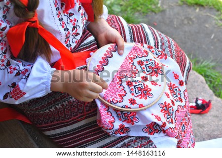 Girl Embroidery Rushnik.Hands of girl woman female in ukrainian traditional shirt sewing embroidery pattern in embroidery frame. Close up. Selective focus