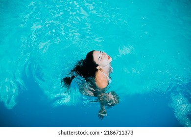 Girl Emerging From The Blue Water In A Swimming Pool On Holiday