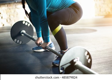 The Girl Is Engaged In Bodybuilding. Deadlift By Women In Black And Blue Clothing.