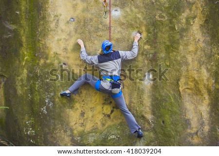 Girl engaged in rock climbing on the cliffs.
