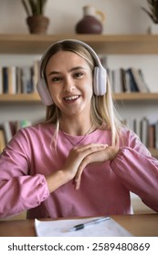 Girl engaging in virtual class or study session with tutor, webcam vertical view, smile, look at camera participate in video call or online discussion with schoolmate. Studying using modern technology