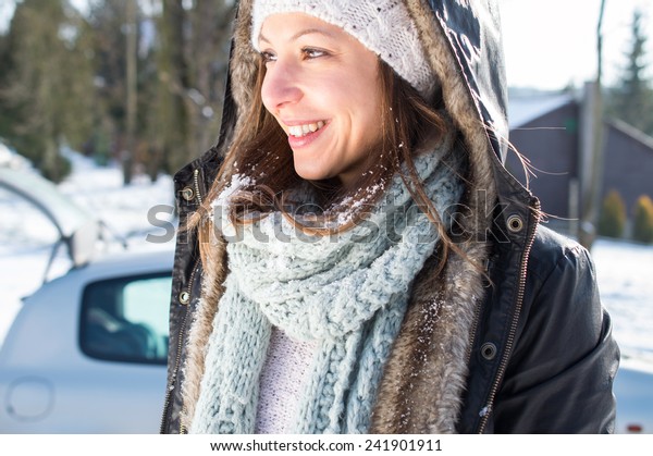 Girl enjoy snow\
and sunshine in winter by\
car