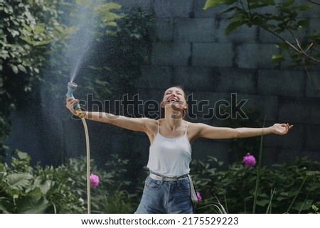 girl enjoying water in the heat of summer in the garden