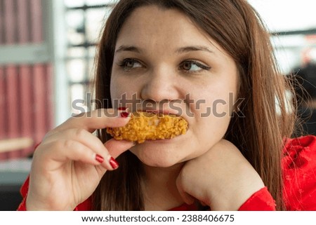 Girl enjoys spicy wings in a cafe