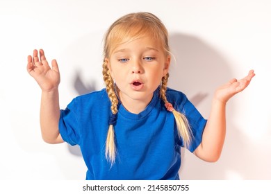 The Girl Expresses Extreme Surprise. The Child Throws Up His Hands In Surprise. A Child's Reaction To A Surprise Or Unexpected Outcome.