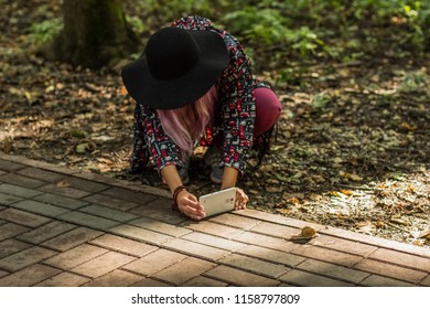 Girl With Face Behind Black Hat Taking Photo On Phone Of Snail In Outdoor Park Nature Environment 