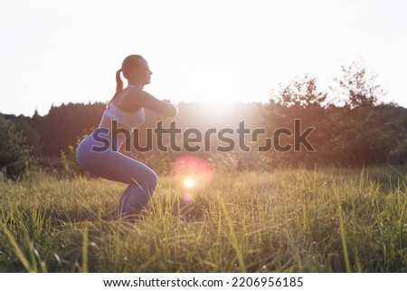 a girl of fair appearance with tied hair, in a fitness suit, is engaged in exercises at dawn in the park, on the right side there is a place for an inscription. The concept of a healthy lifestyle