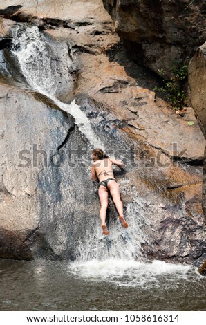 The girl falls down the waterfall, Thailand, around Pai city, April 2014