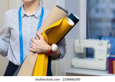 Girl Fashion Designer Sew. Female Tailor, Dressmaker Woman Sewing In Modern Atelier. Seamstress Holding Roll Of Fabric In Workshop 