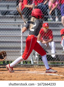 Girl Fastpitch Softball Player In Action During A Competitive Game