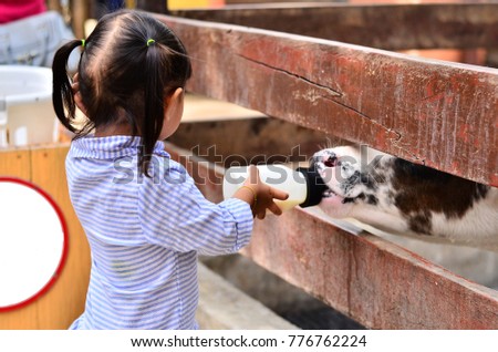 Similar – Image, Stock Photo Little baby cow feeding from milk bottle.