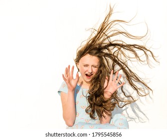 Girl is feeling surprised when long hair is blown high and straight out in a big wind 
