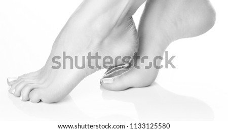 Girl feet dancer. Smooth skin, perfect nail polish pedicure, white background. Black and white
