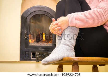 Girl feets in front of a fireplace. 