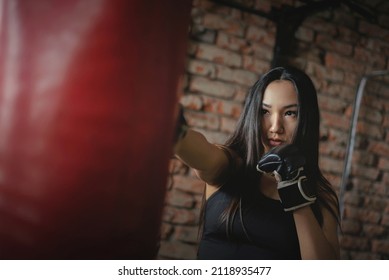 A Girl Fighter Is Punching A Boxing Bag Close Up Concept.