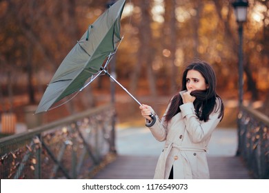 Girl Fighting The Wind Holding Umbrella Raining Weather. Autumn woman having problems in windy storm
