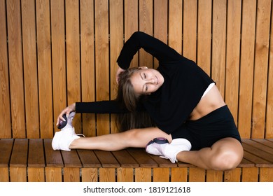 Girl Fitness Trainer Conducts Workout Outdoors. Shows An Exercise To Stretch The Inner Thigh.