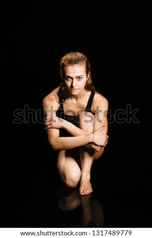 Similar – Close up front upper body portrait of one young athletic woman in sportswear in gym over dark background, looking at camera