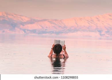 Girl Floating During Sunset In The Dead Sea, Israel