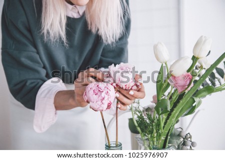 Similar – Woman with peonies on table in the living room