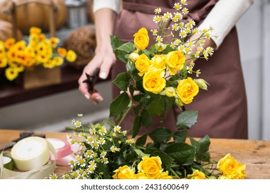 Girl florist makes bouquet.Flowers close-up the hands of florist.Florist cuts rose flowers with secateurs.pruning stems with secateurs.girl cut flowers with secateurs close-up. floristry courses - Powered by Shutterstock