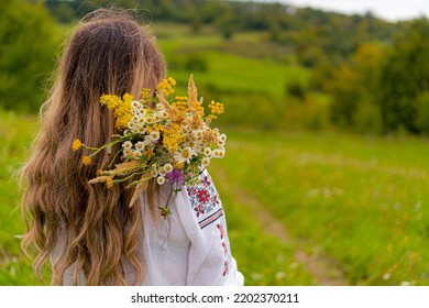 Girl With Flower Bouqet In A Green Field