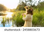 girl in flower wreath stand in river. summer nature background. Floral crown, symbol of summer solstice. ceremony for Midsummer, wiccan Litha sabbat. pagan folk holiday Ivan Kupala