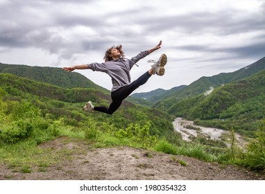 Girl flying in a jump on the background of the mountains