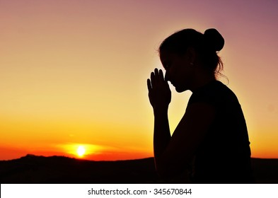 Girl Folded Her Hands In Prayer. Beautiful Sunset. Colorful Sky. Tenderness And Serenity