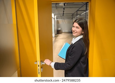 Girl with folders in her hands enters the office premises - Powered by Shutterstock