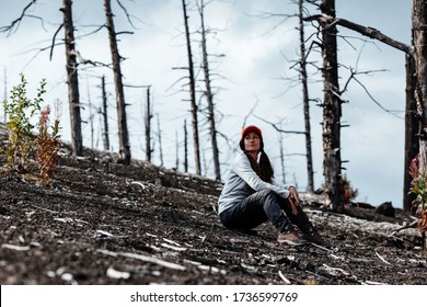 Girl at the foot of a volcano on a background of dead trees