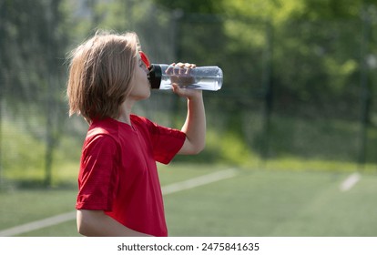 Girl In Football Gear Drinks Water During Training - Powered by Shutterstock