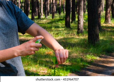 girl in the forest uses the spray against mosquitoes