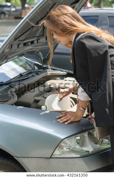 Girl in formal clothes is\
trying to repair the machine. Concept: transport, lifestyle,\
fashion