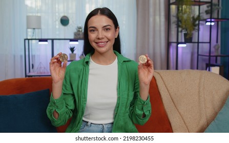 Girl Freelancer Holding Two Gold Coins At Home, Successful Developer Programmer. Woman Stock Trader Earning Bitcoins After Online Monitoring Trading Operations. Increasing Wealth, Financial Prosperity