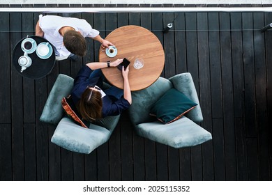 girl freelancer works in a cafe at a table top view. the waiter brings coffee to the woman in the restaurant - Powered by Shutterstock