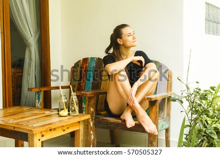 girl with fresh drinks sitting on veranda on vacation