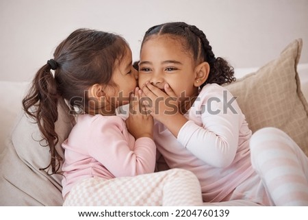 Girl, friends or children whisper secret to best friend on home sofa while relax together on play date. Communication, conversation and sisters or youth kids gossip at fun slumber party or sleepover