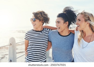 Girl, friends and happy with hug by beach for adventure, vacation joy or laughing with freedom of youth. Female students, walking and holding hands on promenade for summer break, holiday and carefree - Powered by Shutterstock