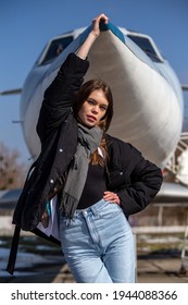 Girl In Front Of A Small Plane, Holding Nose Of A Plane