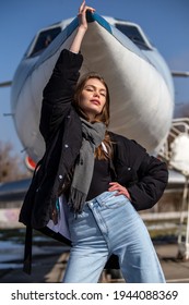 Girl In Front Of A Small Plane, Holding Nose Of A Plane