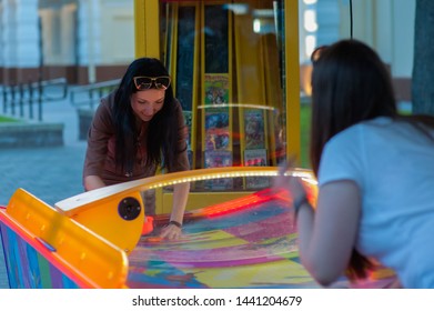 Girl Fun Playing Slot Machines. Children And Adults Play Slot Machines, Attractions In The Mall. Families With Children Have Fun And Play Arcade Games On Computer Machines.