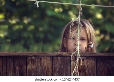 Girl Funny Playing Hide And Seek. The Young Child Thinks She Will Not Be Found. A Child Who Does Not Know How To Play Hide And Seek. I See No One - It Means No One Sees Me.