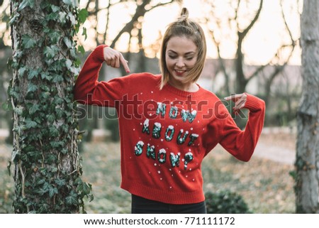 Girl in funny sweater posing outdoor.