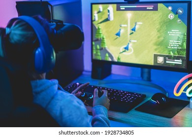 Girl gamer playing strategy game online using virtual reality headset - Soft focus on right hand