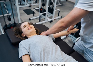 Girl Gets Chiropractic Shoulder Therapy From Man Physical Therapist In Sports Injury Rehab Clinic