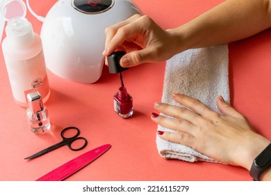 Girl Getting A Manicure. Picking Up The Nail Polish Brush. Painting Your Nails Red