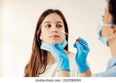 A girl getting tested on covid 19 with PCR test cotton swab. Prevention, medical care and medical service. - Shutterstock ID 2107085099
