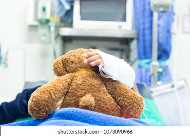 The Girl Was Given Intravenous Fluid Hugging A Teddy Bear While Lying In The Emergency Room Of The Hospital.